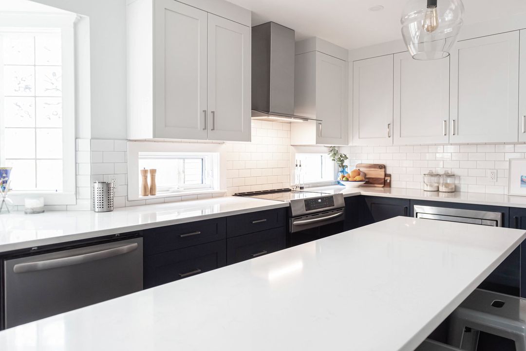 Modern kitchen with sleek white quartz countertops and minimalist cabinetry, highlighting how quartz countertops offer design control for a clean, contemporary aesthetic.