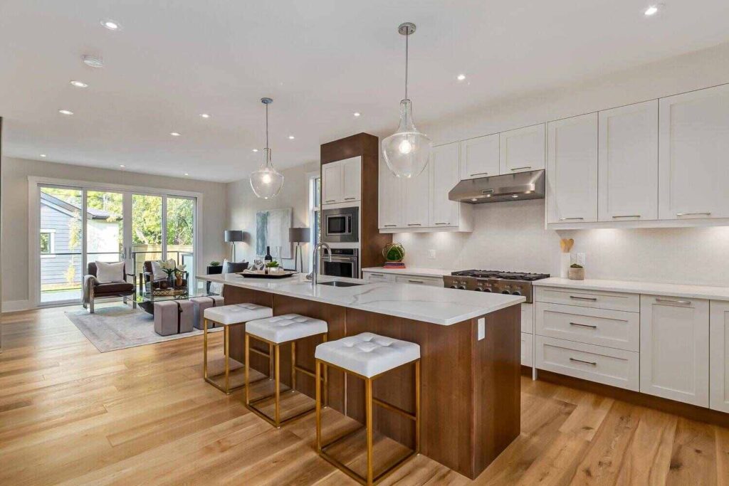 Kitchen Reno Timeline: How Long Cabinets Actually Take (From Design to Install) 2 Spacious modern kitchen with custom cabinetry and island seating, highlighting factors that impact cabinet timelines in kitchen renovation projects.