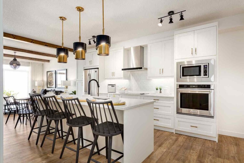 Cabinet Delivery and Jobsite Logistics for Calgary Contractors: What to Plan Before Cabinets Arrive 1 Modern residential kitchen with dark cabinetry and island, illustrating cabinet delivery planning for efficient construction schedules.